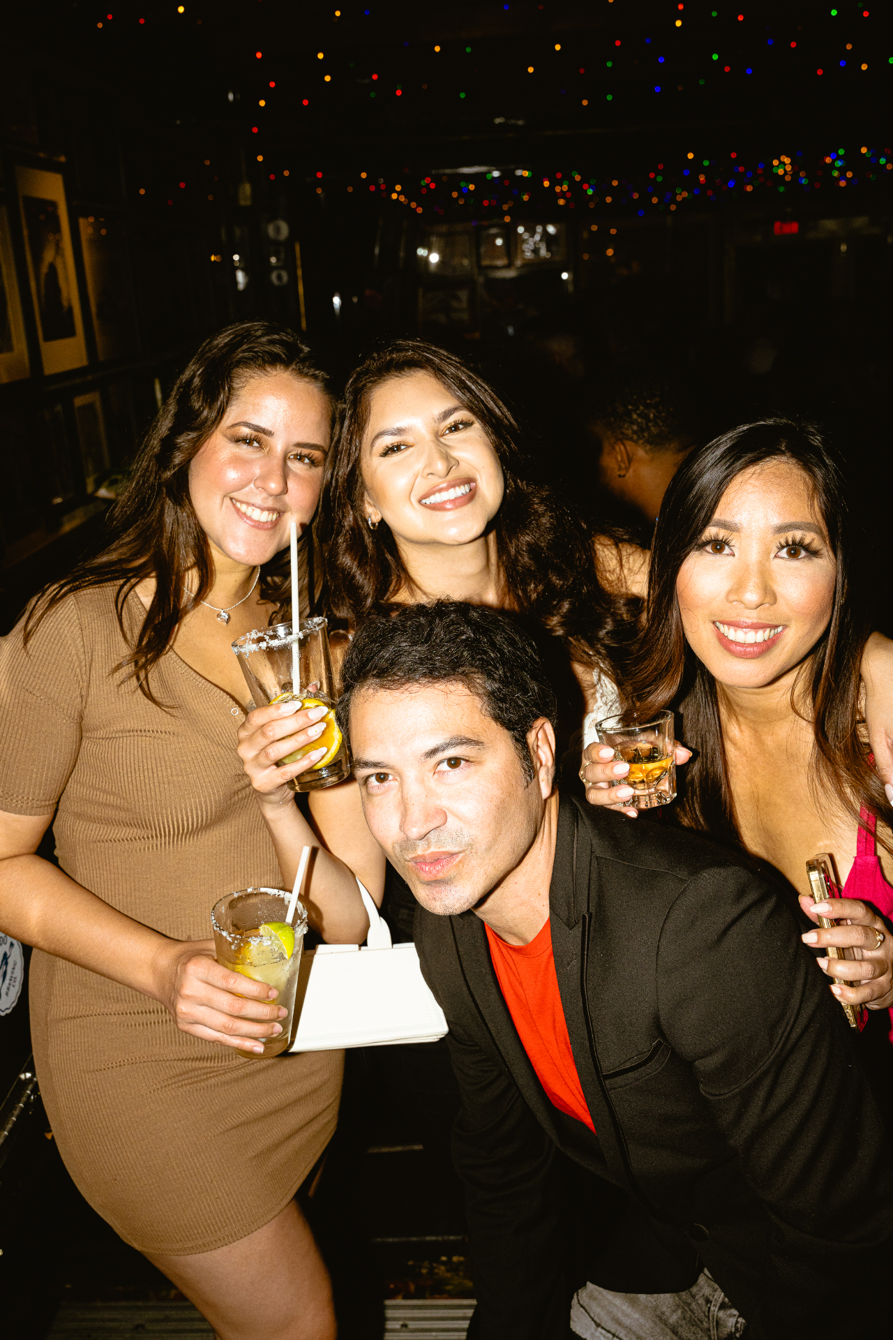 Friends out drinking under Christmas lights at Waterfront in Little Italy at night