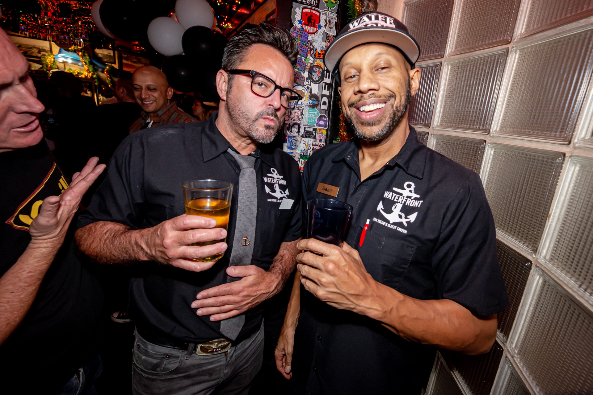 Waterfront staff members posing together in front of the bar's glass-block wall